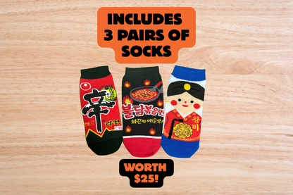 Three pairs of Korean socks with colorful designs on a wooden surface, including text indicating they are included in a set worth $25.